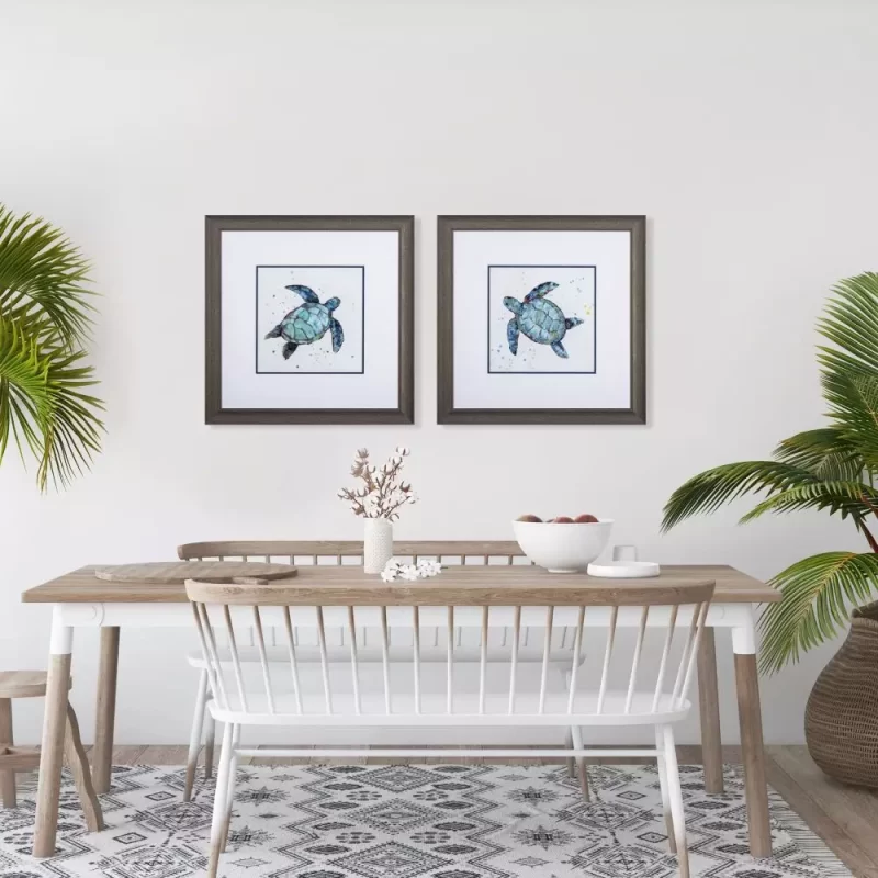Set of 2 blue turtle art prints over a table.